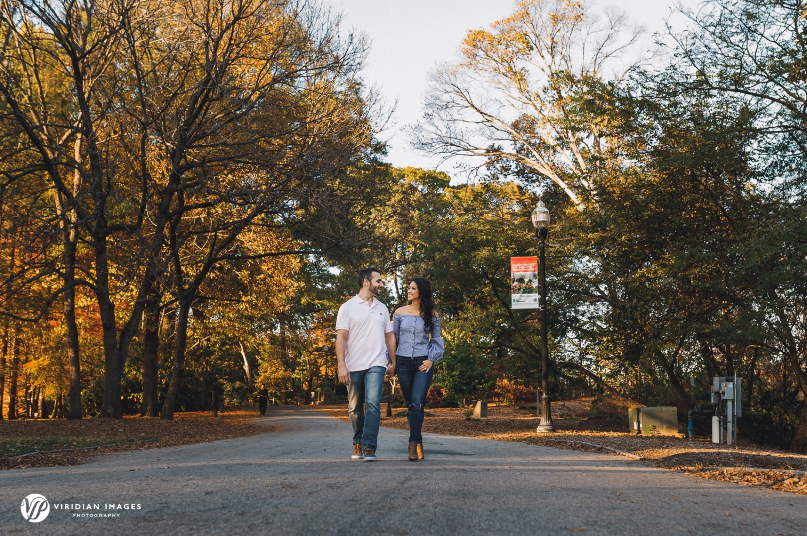 Playful engagement photo of couple walking along path at Piedmont Park