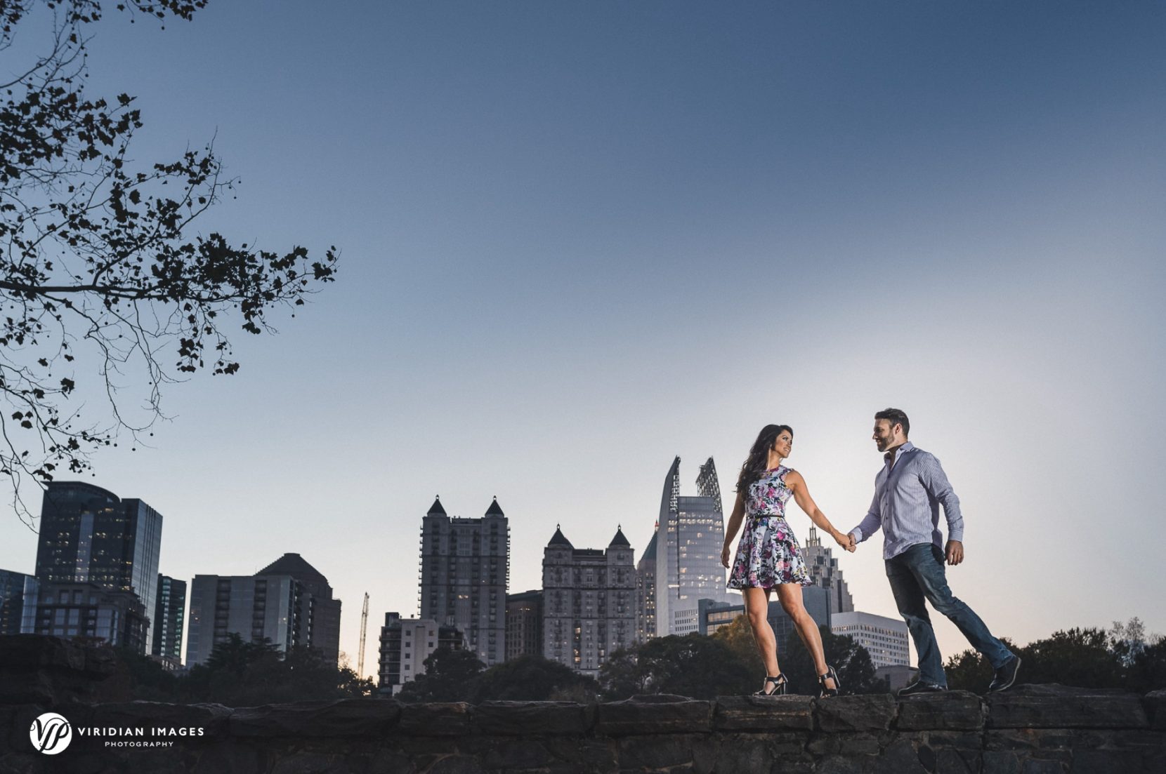 Romantic golden-hour engagement portrait against city skyline in Atlanta