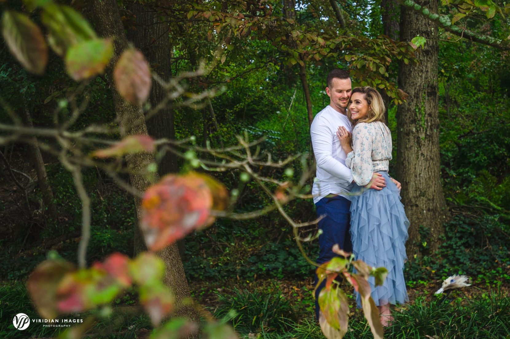 Couple enjoying each other under fall colored trees in Atlanta park