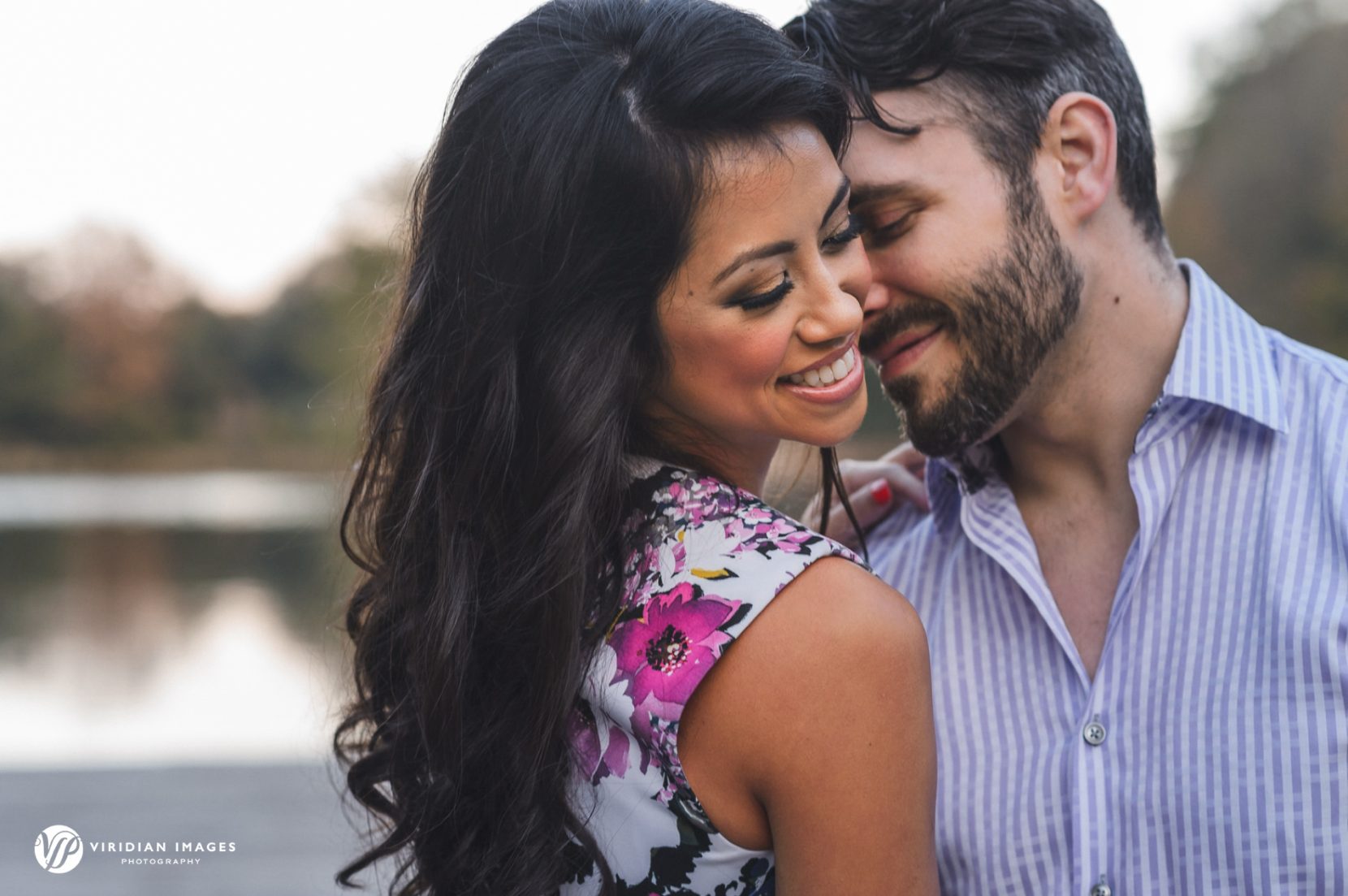 Romantic couple standing on dock during engagement photos
