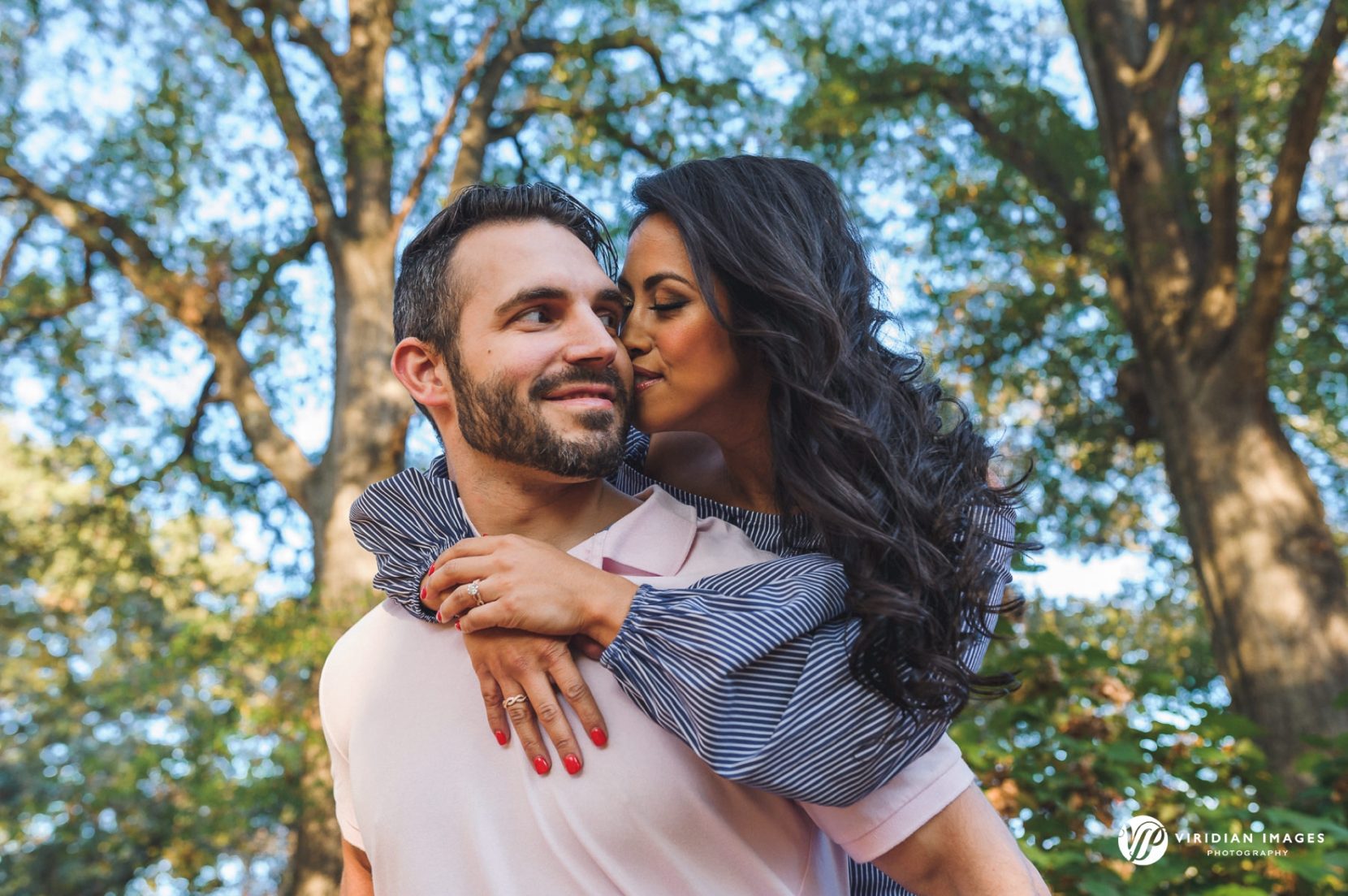 Couple having fun with piggy-back ride along path at Piedmont Park