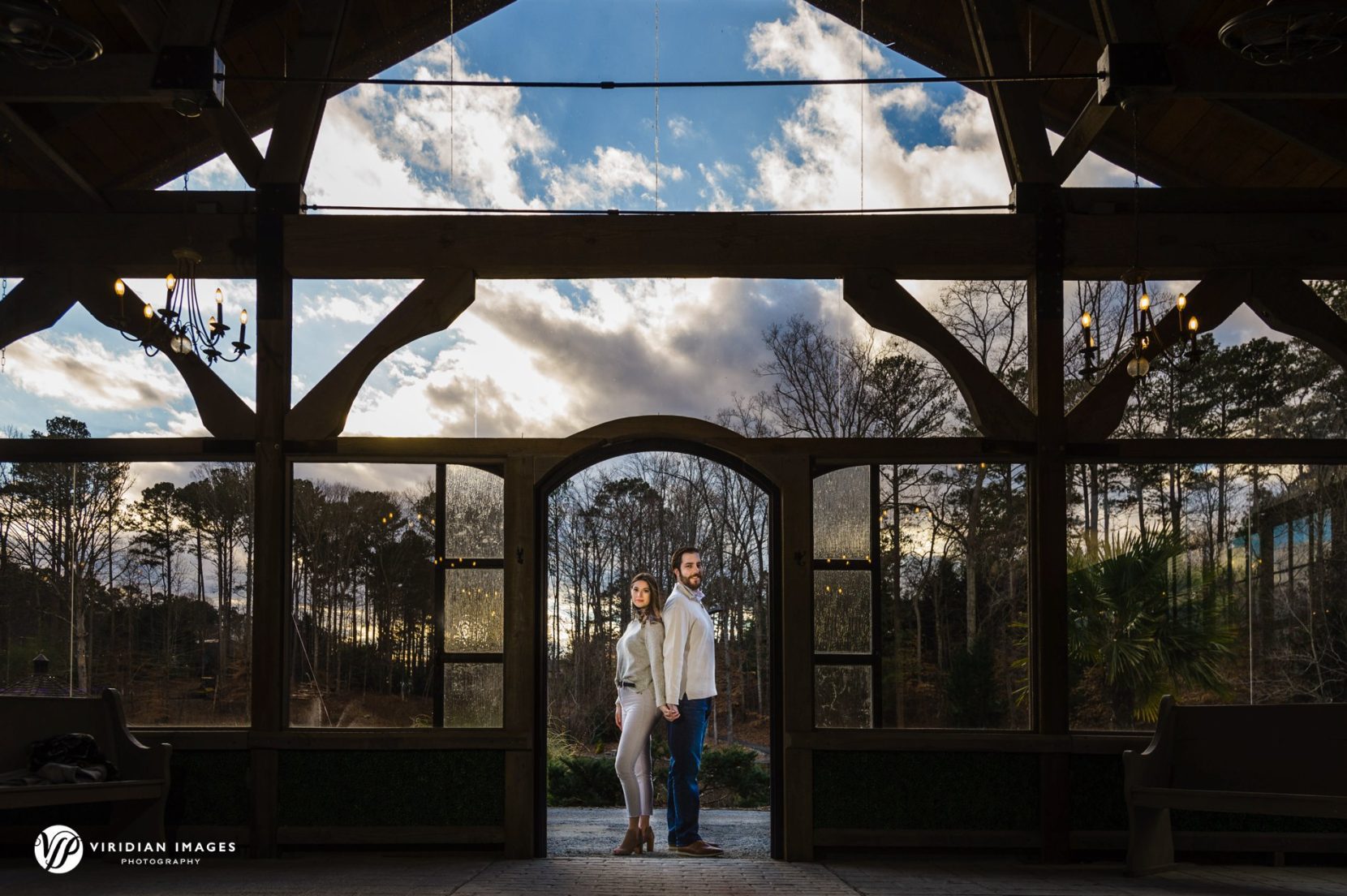 Dramatic late afternoon sky shown through pavilion glass wall during engagement session at Rocky Lake.