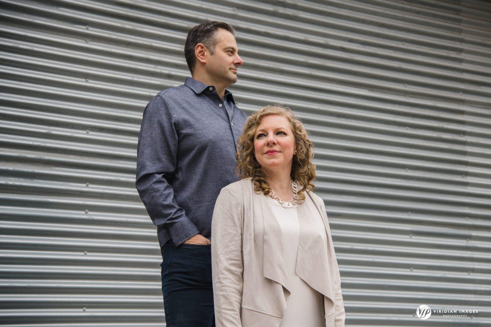 Editorial style engagement photo against metal corrugated wall at Sweetwater Creek Park