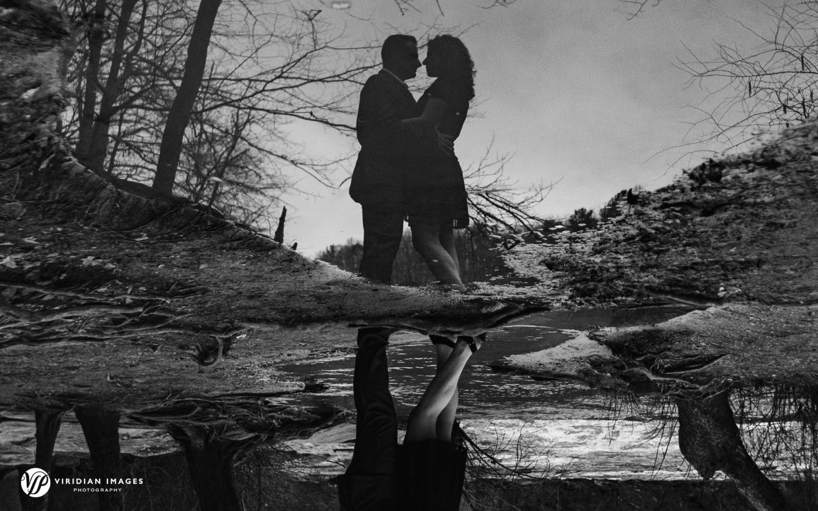 Reverse reflection of couple standing along creek at Sweetwater