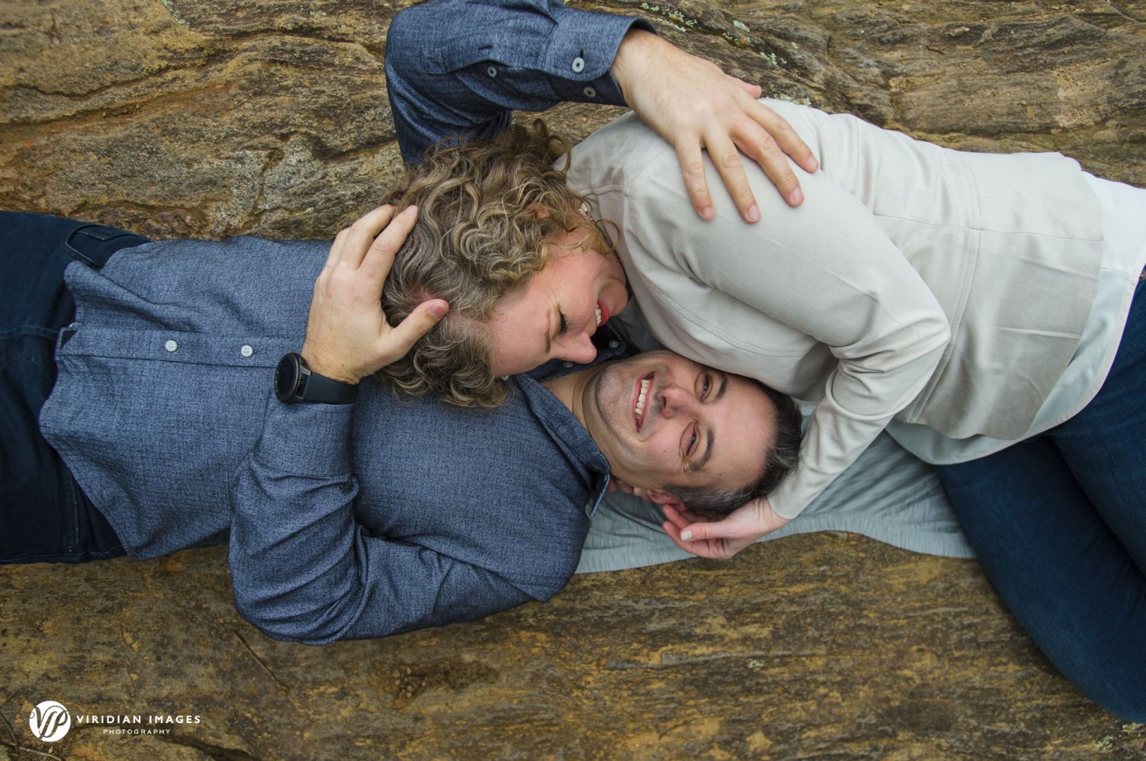 Birdseye view of couple lying on rock with heads side by side at Sweetwater Creek Park