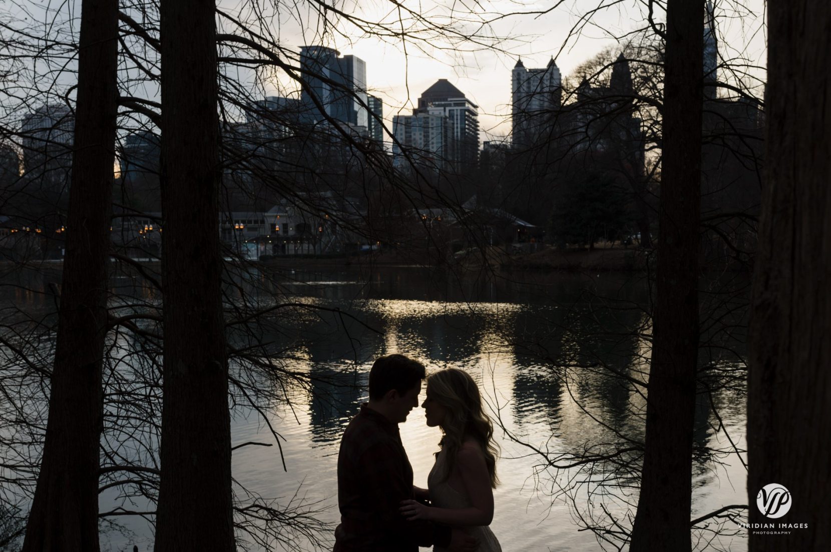 Creative engagement photo silhouette against lake and city skyline at Piedmont Park
