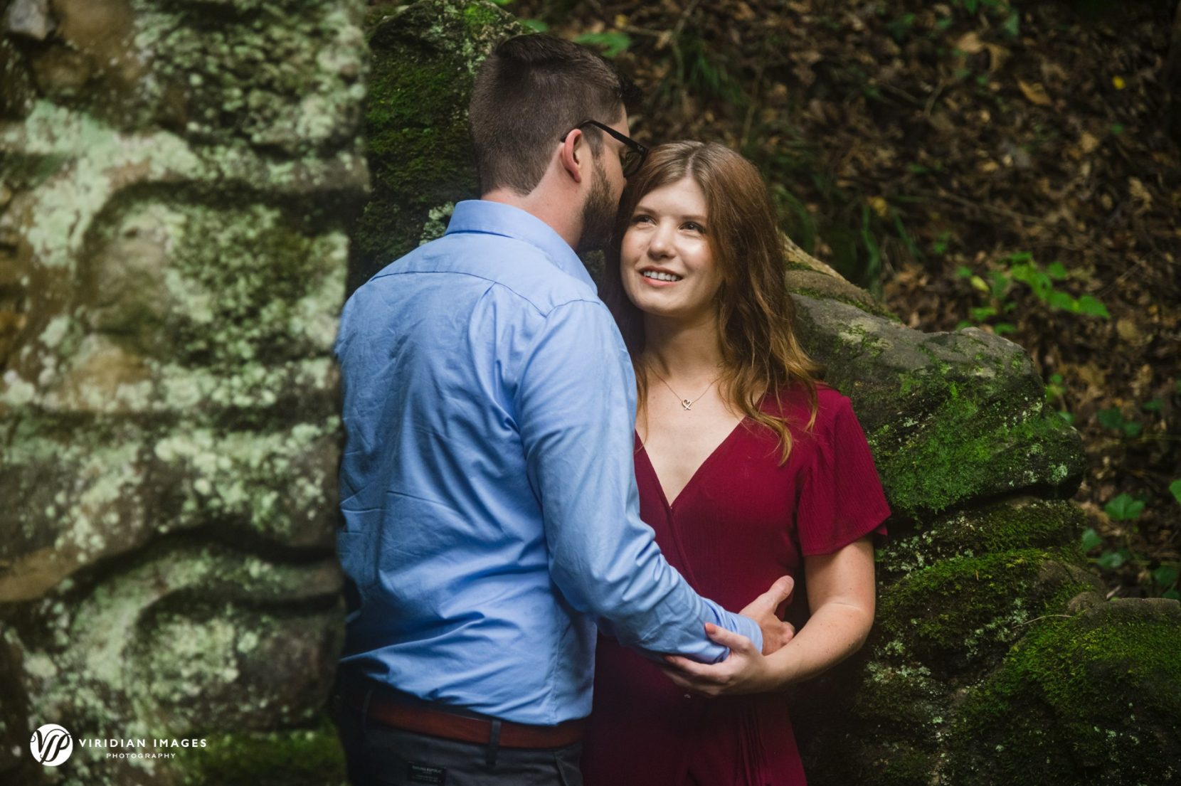 Engaged couple holding each other along forest trail at Cascade Springs Natural Preserve