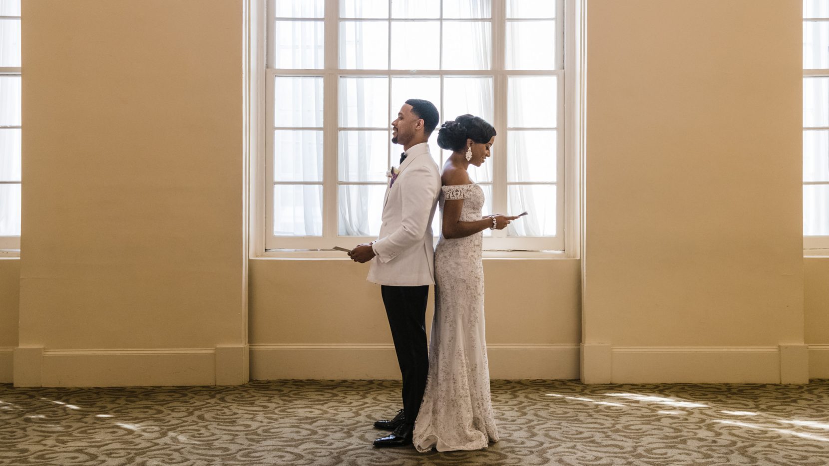 Couple back to back reading vows during first look inside Biltmore Ballrooms Atlanta