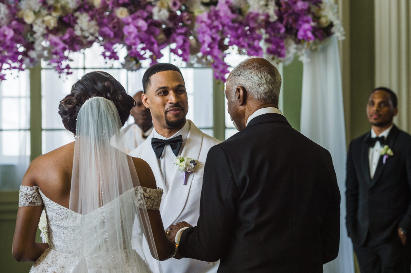 Father or bride handing daughter to groom at the altar during ceremony at Biltmore Ballrooms Atlanta