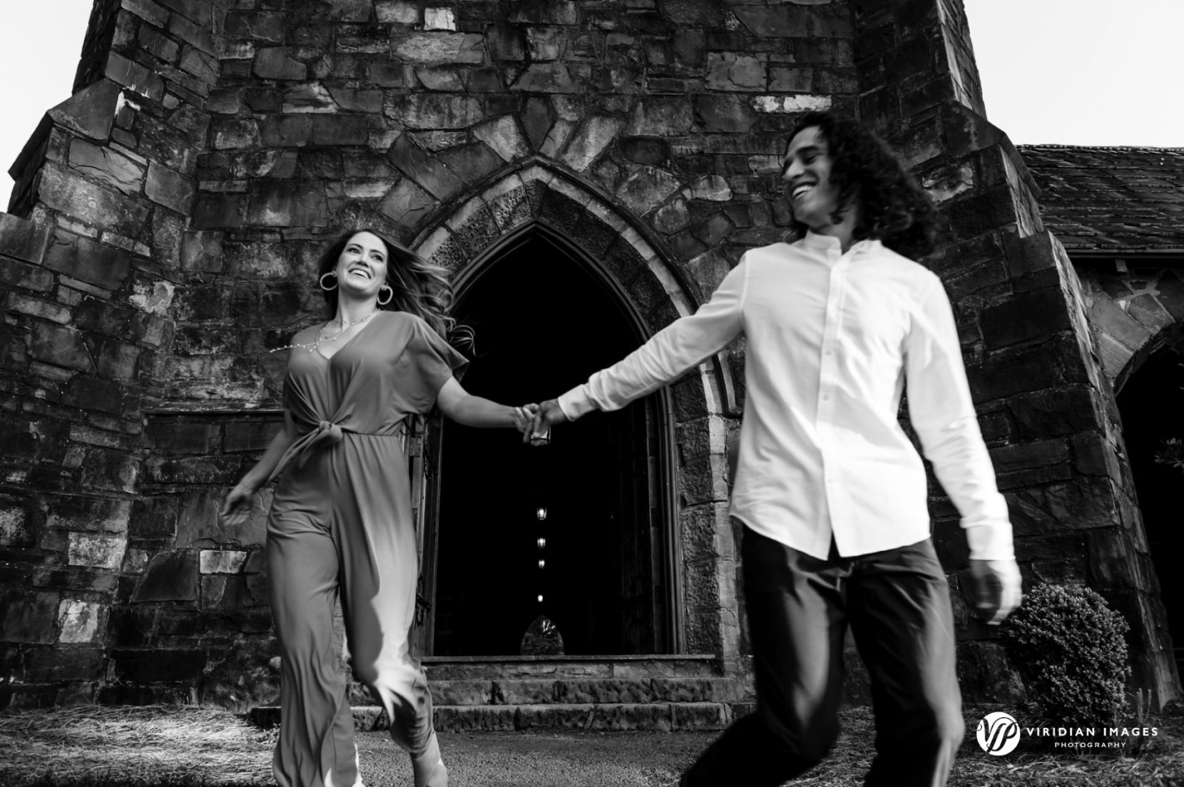 Engaged couple running outside Frost Chapel at Berry College Georgia