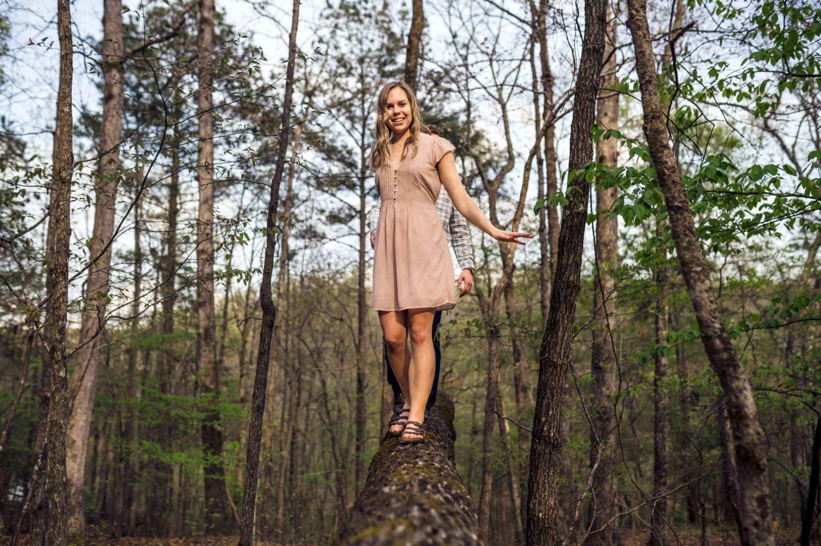 Couple having fun balancing on fallen log at Sweetwater Creek State Park in Atlanta