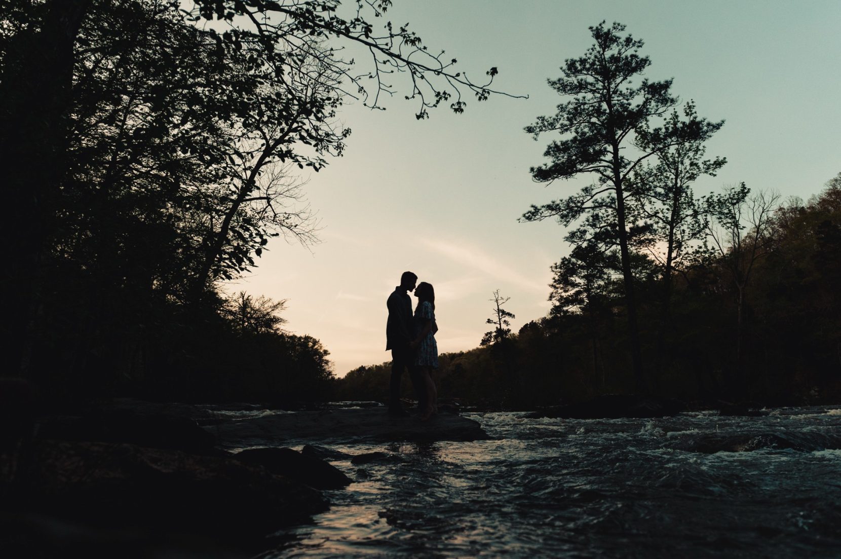 Romantic photo of couple together during sunset on the river at Sweetwater Creek Park
