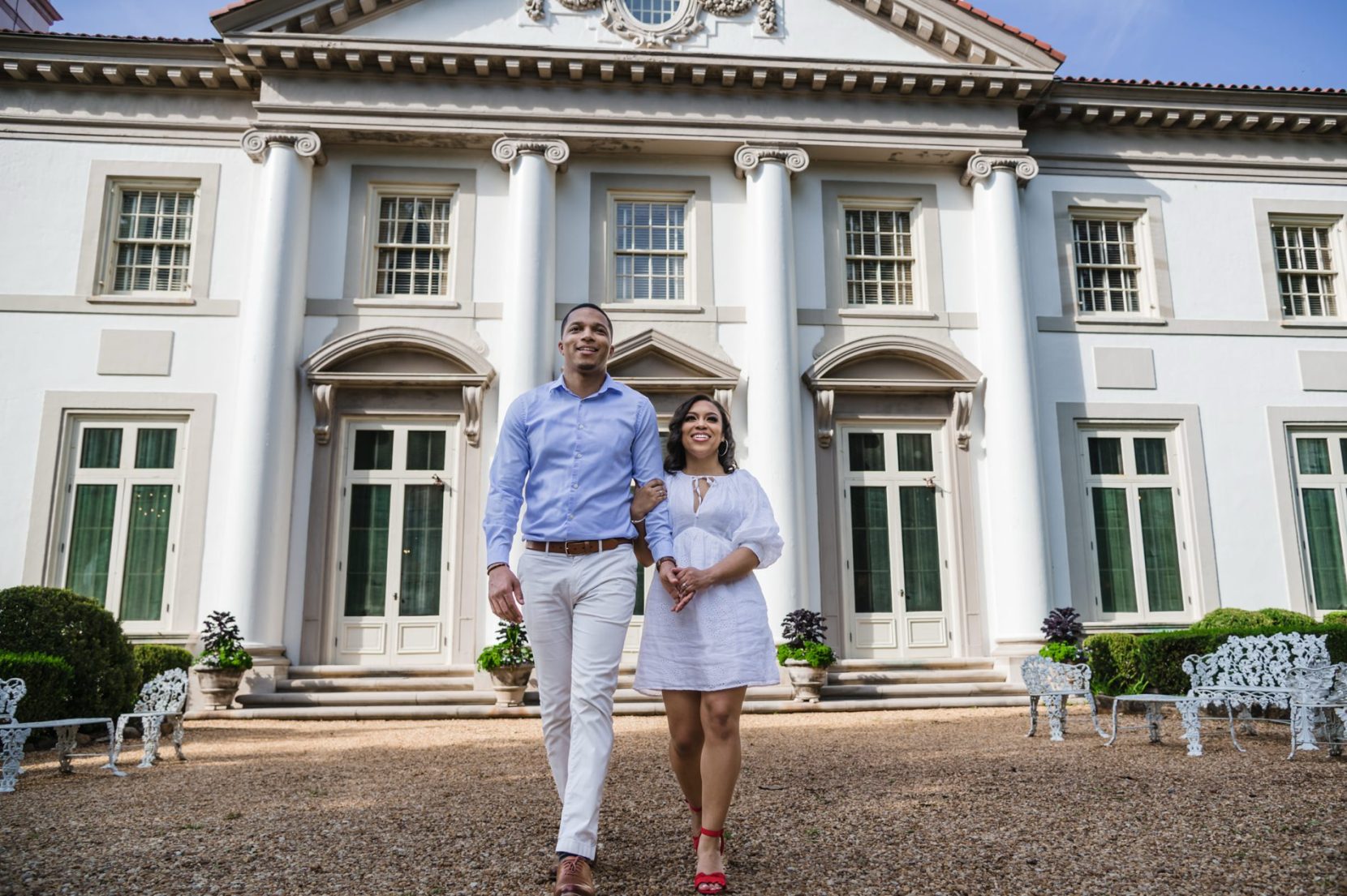Couple walking in front of Hills and Dales mansion during engagement session