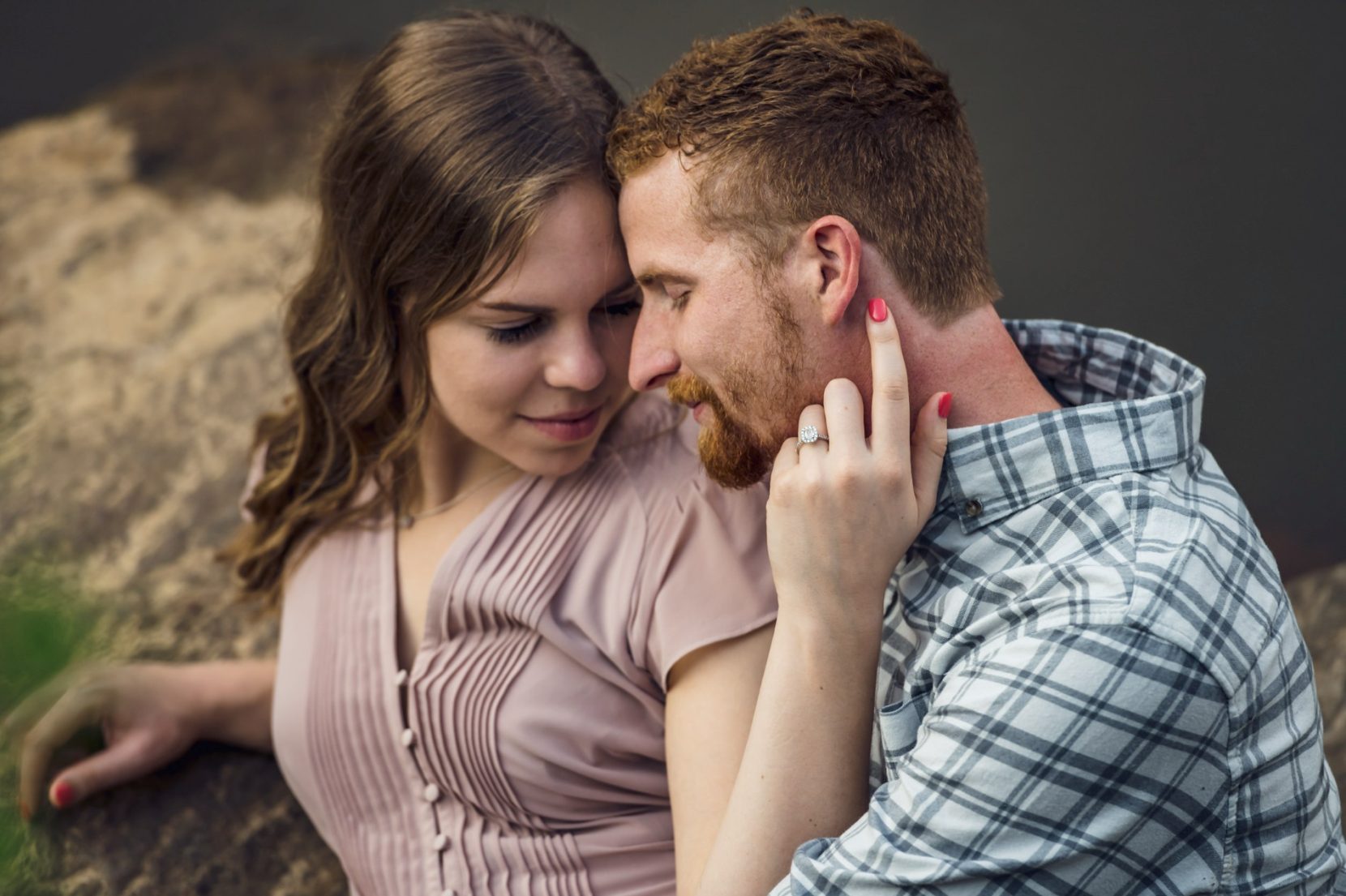 Romantic couple cuddling together while lying on rock