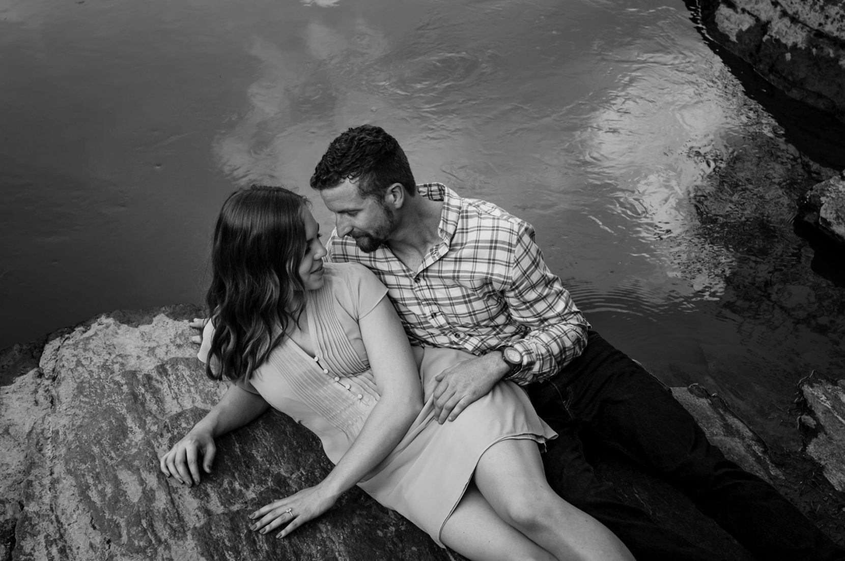Private moment along river of couple in love during engagement session at Sweetwater Creek Park
