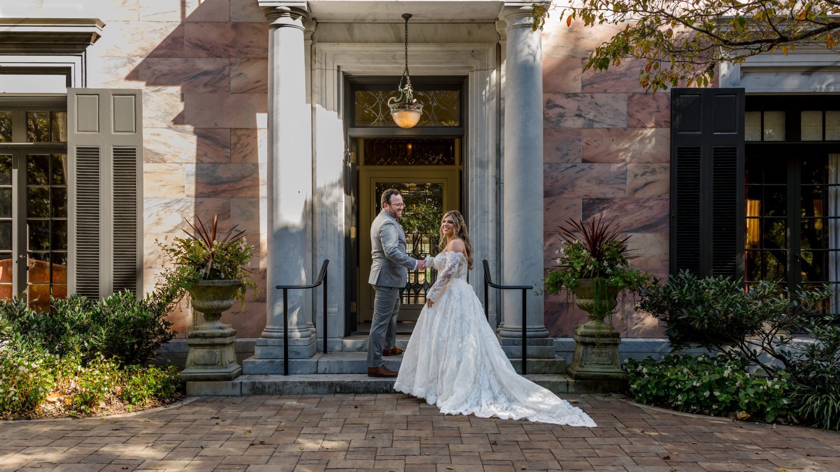 Couple standing together outdoors at sunset with soft directional light at an estate venue