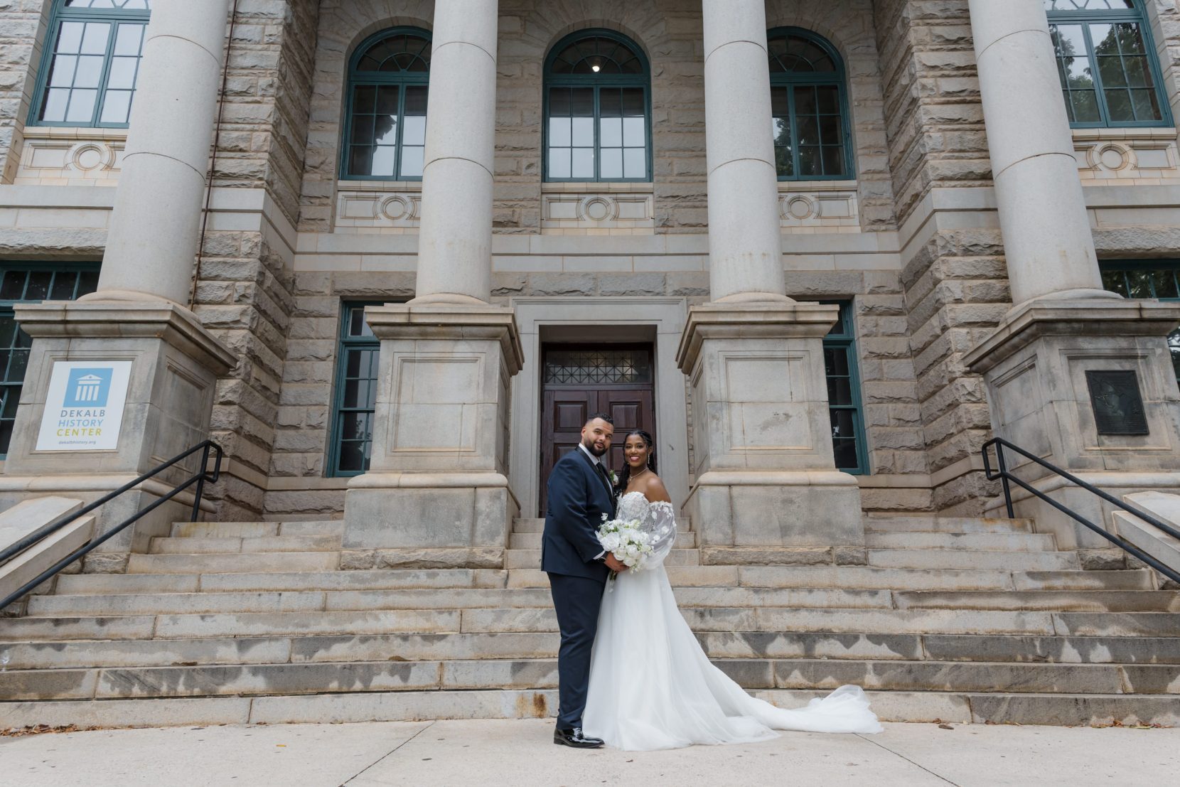 Couple standing centered on steps with symmetrical architectural framing