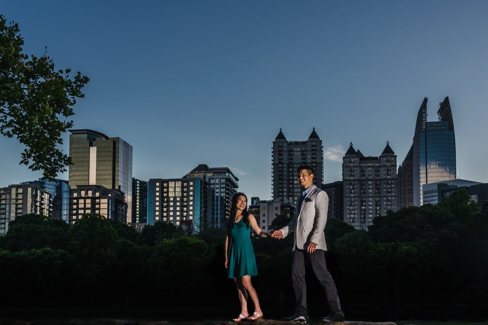 Blue hour engagement photo with city skyline view at Piedmont Park