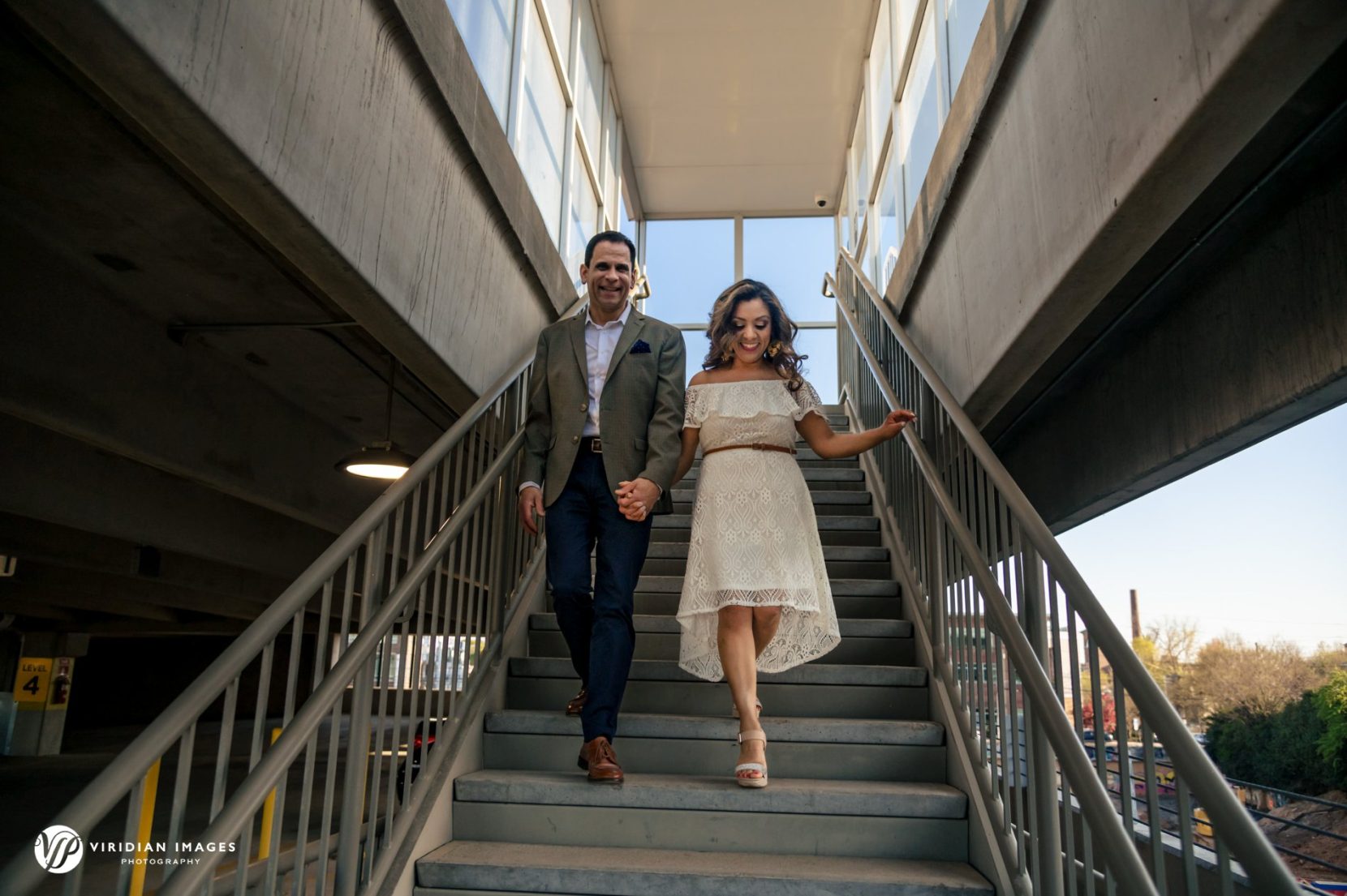 Couple walking down stairs during engagement session at StudioPlex Atlanta